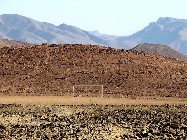 Staatsmotto "Gott, Vaterland, König" hinter dem Tor mit Steinen in den Hang gelegt